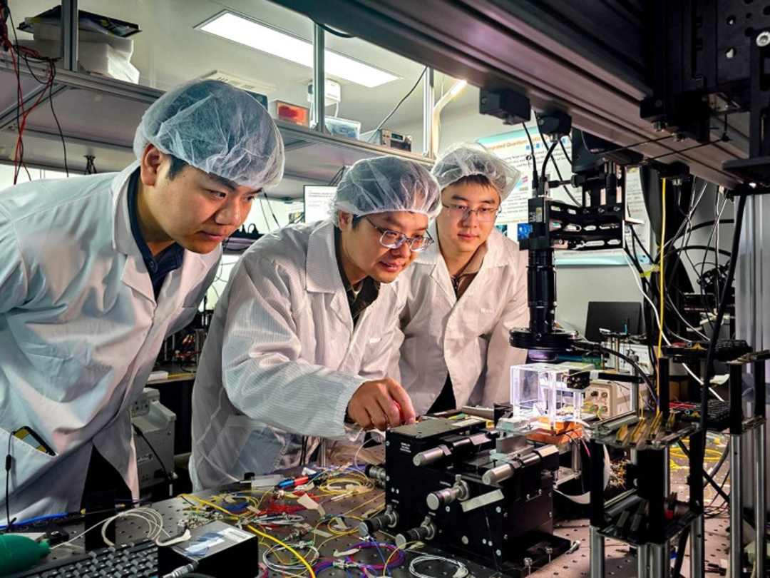 北京大学的研究团队正在测试一款集成光量子芯片。来源：Xinhua via Alamy